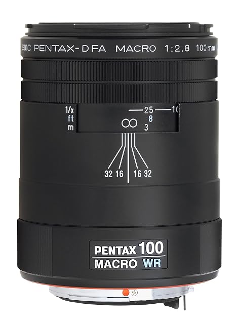 Objectif macro Pentax D FA 100mm WR noir à fût d’aluminium, son pare-soleil posé à côté